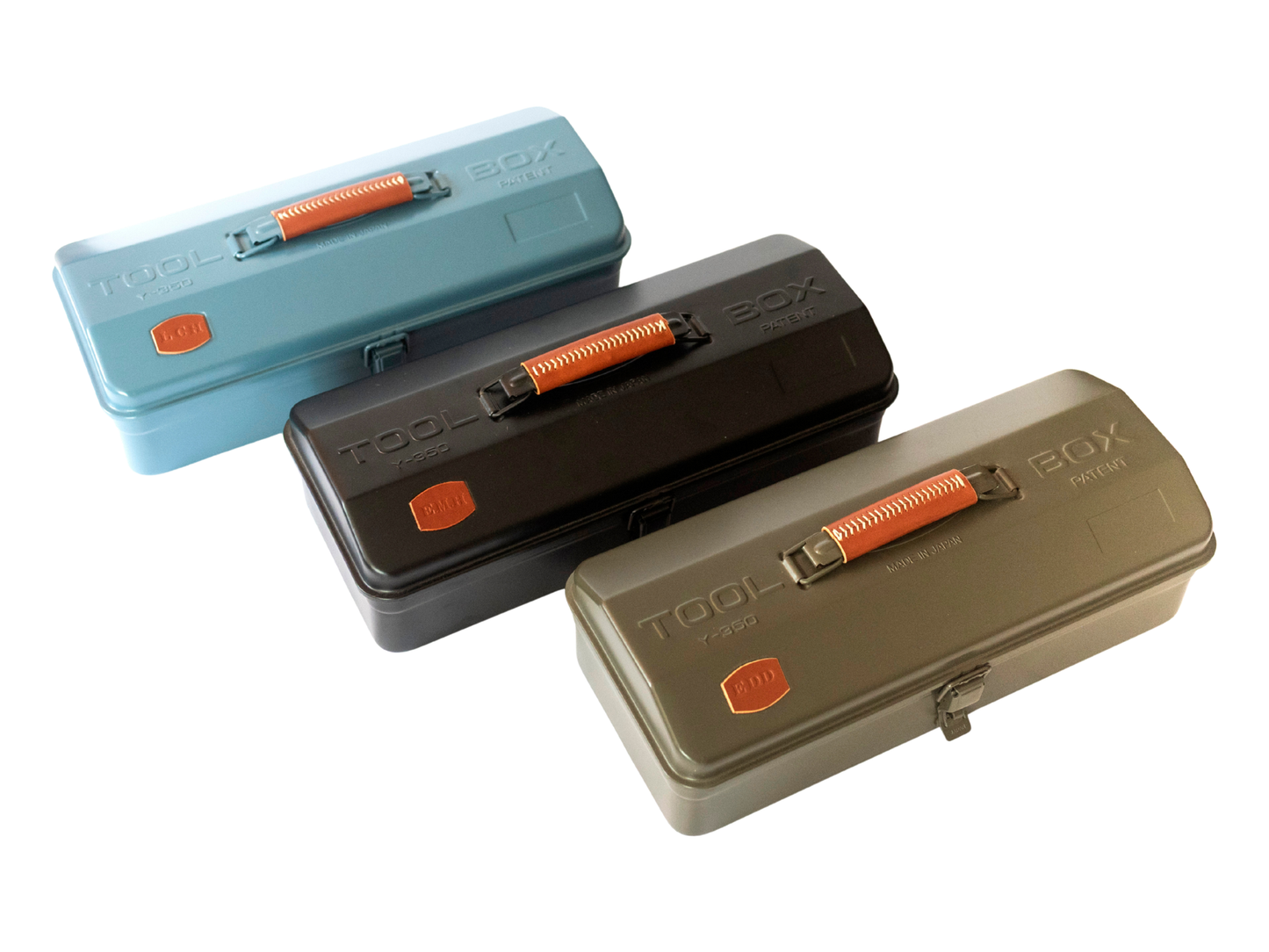Three rectangular TOOL BOX 301A tool cases shown on a white background, arranged diagonally. The cases are in light blue, dark gray, and olive green, each with an orange handle and a small orange logo badge.