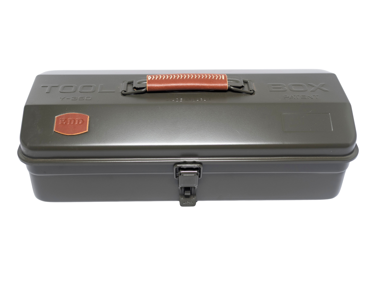 A dark gray metal tool box with a textured orange-brown handle and a small orange shield logo on the lid, set against a plain white background.