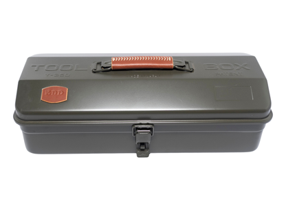 A dark gray metal tool box with a textured orange-brown handle and a small orange shield logo on the lid, set against a plain white background.