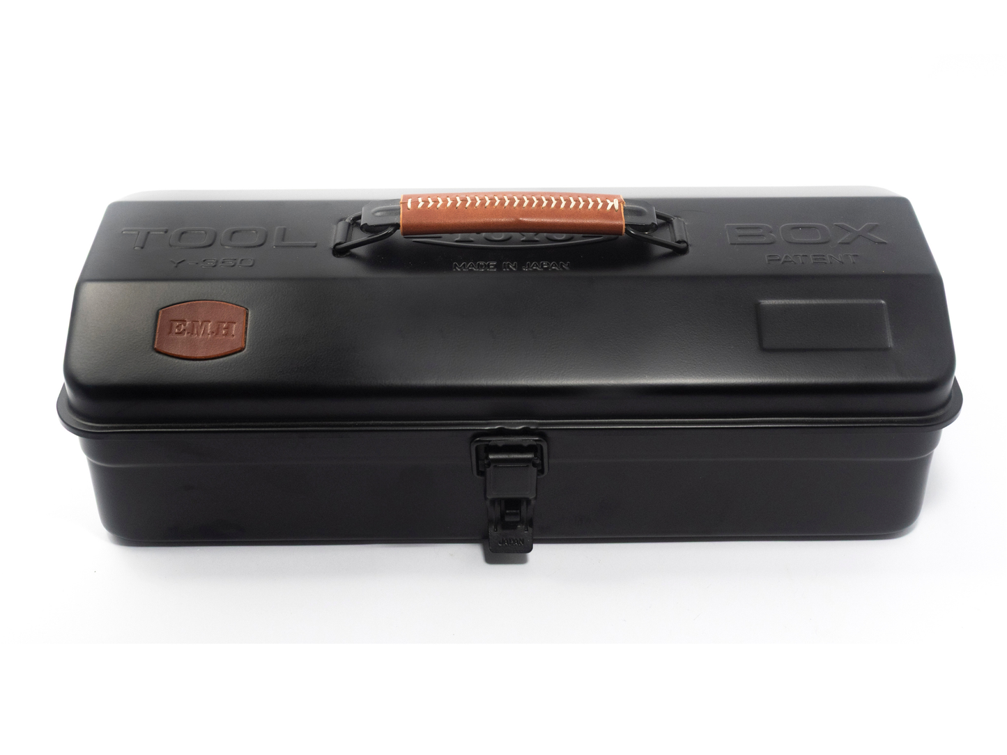 A black plastic tool box with a top handle, embossed 'TOOL BOX' text, and a small orange-brown brand patch on the left side, shown on a white background.