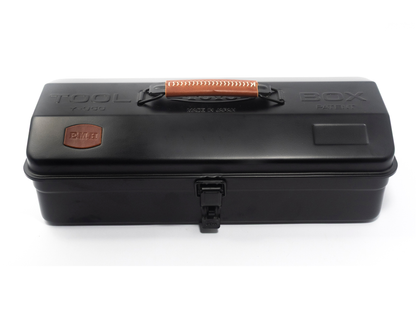 A black plastic tool box with a top handle, embossed 'TOOL BOX' text, and a small orange-brown brand patch on the left side, shown on a white background.
